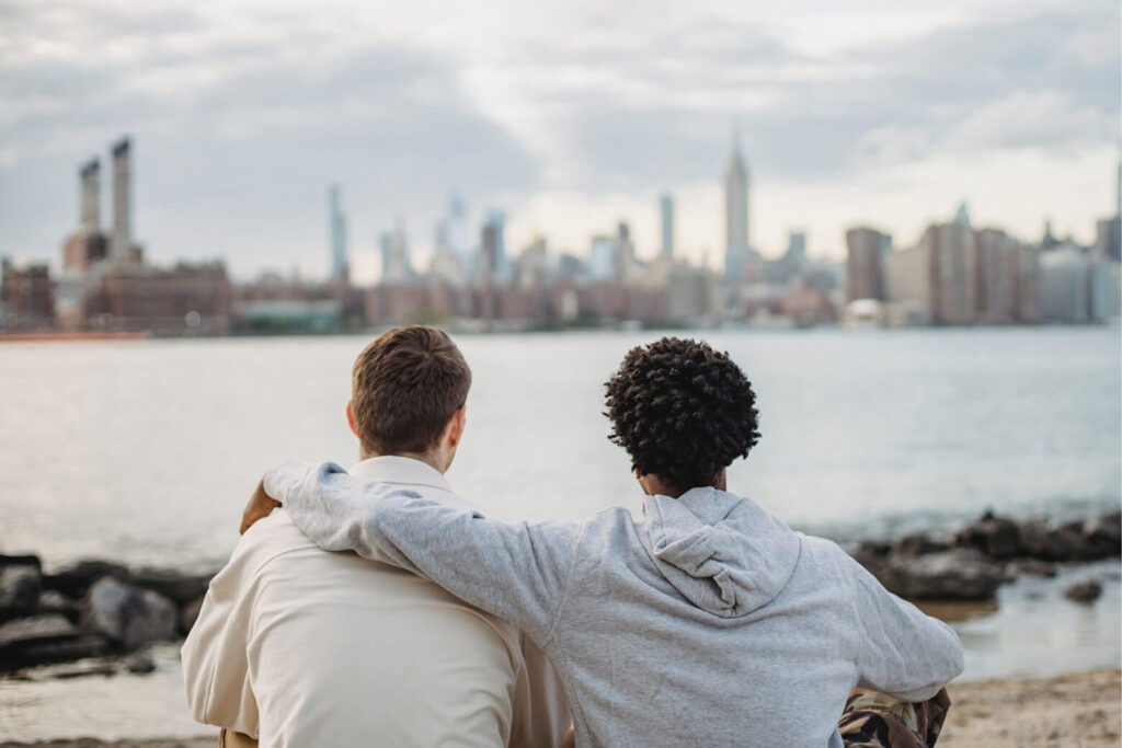 Two people sitting and looking out at city